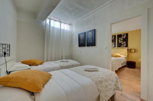 two beds in a room with white walls at Hôtel Paul in Aix-en-Provence