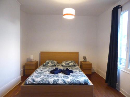 - une chambre dotée d'un lit avec des vêtements bleus dans l'établissement Spacieux T2 proche gare, au Havre