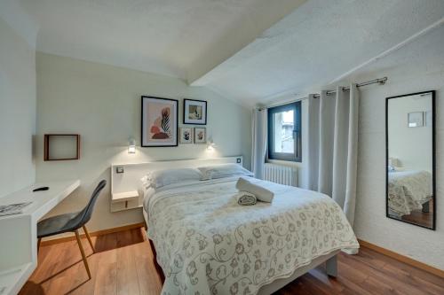 a bedroom with a bed and a desk and a window at Hôtel Paul in Aix-en-Provence