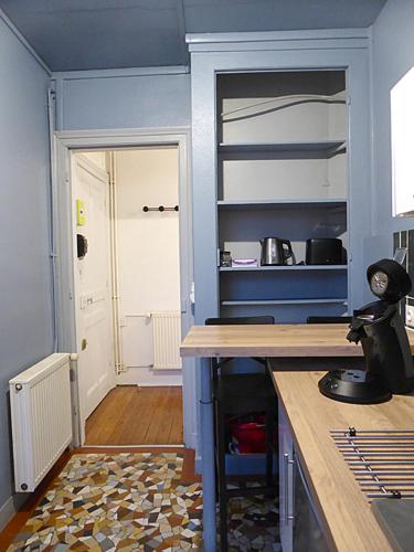 une cuisine avec des murs bleus et un comptoir. dans l'établissement Spacieux T2 proche gare, au Havre