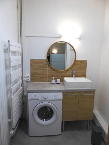 une salle de bain avec une machine à laver et un lavabo dans l'établissement Spacieux T2 proche gare, au Havre