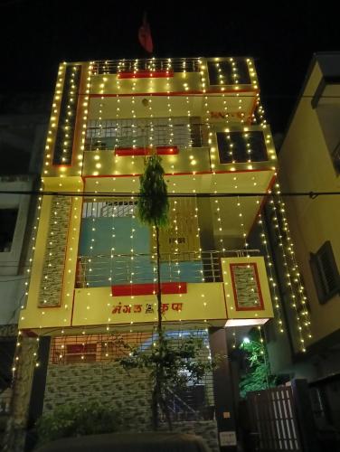 a tall yellow building with lights on it at Mangal kripa homestay in Ujjain