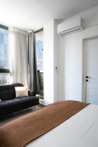 a bedroom with a bed and a couch and a window at Haim Arlosoroff Residence - MAMAD in Tel Aviv