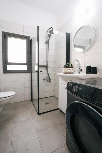 a bathroom with a shower and a washing machine at Haim Arlosoroff Residence - MAMAD in Tel Aviv