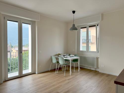 a dining room with a table and chairs and windows at Fiore di Lago in Colico