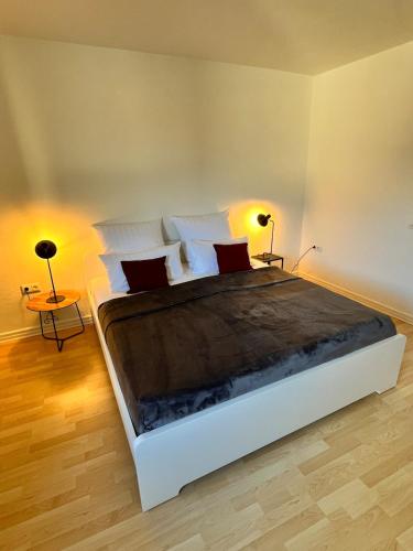 a bedroom with a large bed with two lamps at Zentrumsnahe Wohnung, Anviolhomes in Hannover