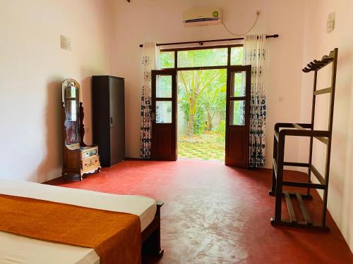 a bedroom with two beds and a door to a yard at Villa Ocean Whisper in Induruwa