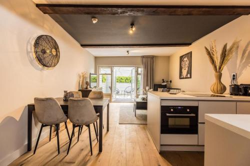 Una cocina y una sala de estar con mesa y sillas. en Haya Historic - Pinot Noir, en La Haya