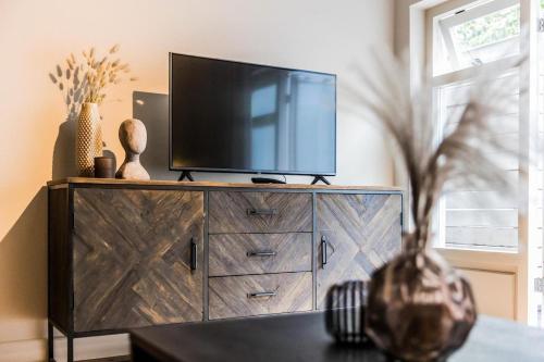 a television on top of a dresser in a living room at Haya Historic - Pinot Noir in The Hague