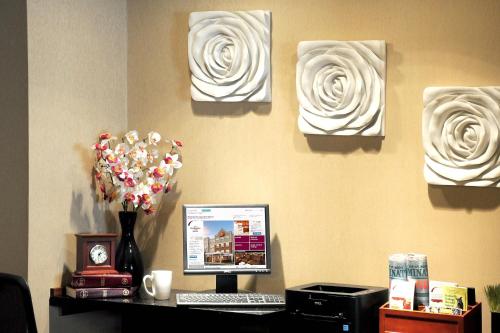 a desk with a computer and flowers on a wall at Residence Inn Long Island Holtsville in Holtsville