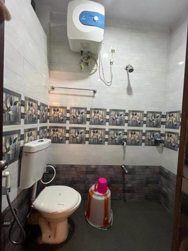 a bathroom with a toilet and a camera on the wall at BanyanThree in Kodaikānāl