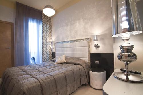 a bedroom with a bed and a table with a lamp at Hotel Villa Paola in Rimini
