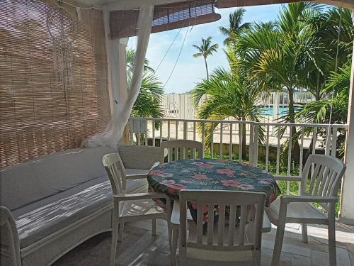 a table and chairs on a porch with a bench at Just in paradise in Baie Nettle