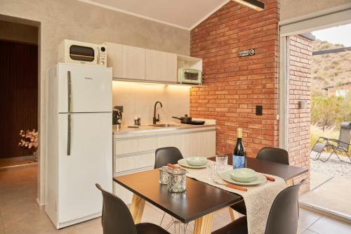 a kitchen and dining room with a table and a refrigerator at La Quebrada Potrerillos - Lodges de Montaña in Potrerillos