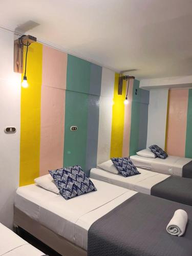 two beds in a room with colorful walls at Point Break Santa Teresa in Santa Teresa Beach