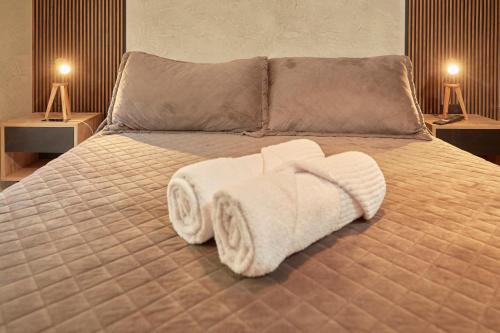 a bedroom with a bed with towels on it at La Quebrada Potrerillos - Lodges de Montaña in Potrerillos