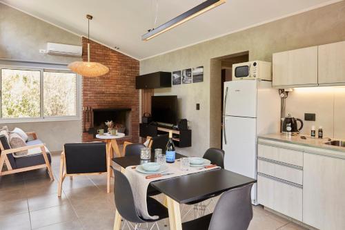 a kitchen and living room with a table and chairs at La Quebrada Potrerillos - Lodges de Montaña in Potrerillos