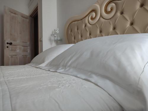 a bed with white sheets and a brown headboard at ROSSINI GUEST HOUSE in Martina Franca