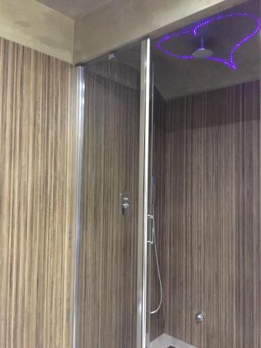 a bathroom with a shower with a purple light on the ceiling at Hotel Smeraldo in Qualiano