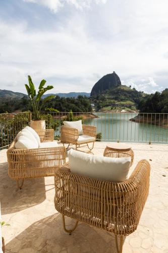 a group of wicker chairs and tables on a patio at MYLOS Hotel Boutique in Guatapé