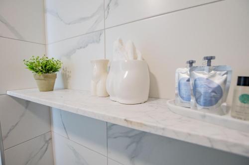 a bathroom shelf with white vases and toothbrushes at Merchants Rest in Galway