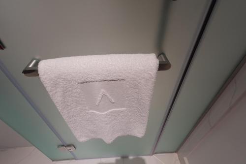 a towel hanging from a ceiling in a bathroom at Address Residence Bahrain in Rayyā