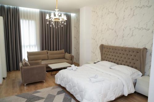 a bedroom with a large bed and a chandelier at Kashar Hotel 3A in Tirana