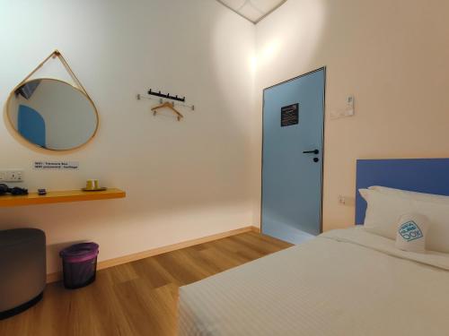 a bedroom with a bed with a mirror and a door at TREASURE BOX At Heritage Georgetown in George Town