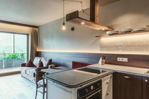 a kitchen with a stove and a couch in a room at Hosler in Merano