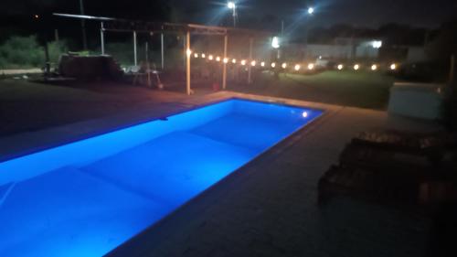 a swimming pool at night with blue illumination at Casa Quincho Pileta Estadio Unico Froilan in Santiago del Estero