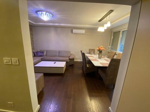 a living room with a couch and a dining table at Belgrade Apartment PetraLUX in Belgrade