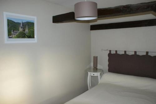 - une chambre blanche avec un lit et une lampe dans l'établissement La Maison de Jeanne, à Altillac