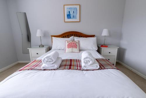 a bedroom with a bed with towels on it at Stouts Court Apartment in Lerwick