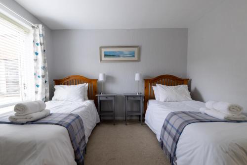 a bedroom with two beds with towels on them at Stouts Court Apartment in Lerwick