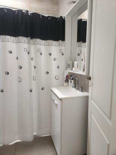 a white bathroom with a shower curtain and a sink at Duplex en Gualeguay in Gualeguay