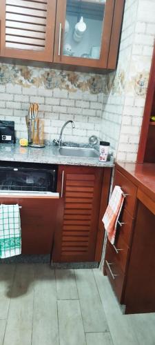 a kitchen with wooden cabinets and a sink at Квартира Olimbe in Yaoundé