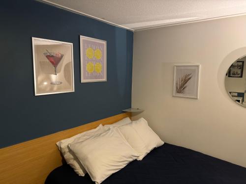 a bedroom with a bed and some pictures on the wall at Peaceful room on a houseboat in the city centre in Amsterdam