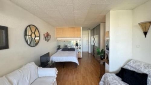 un salon avec un canapé blanc et une chambre avec un lit dans l'établissement NATURISME LE CAP D'AGDE APPART. 4 PERSONNES D 63, au Cap d'Agde