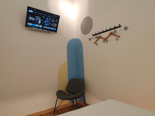 a room with a chair and a tv on the wall at TREASURE BOX At Heritage Georgetown in George Town