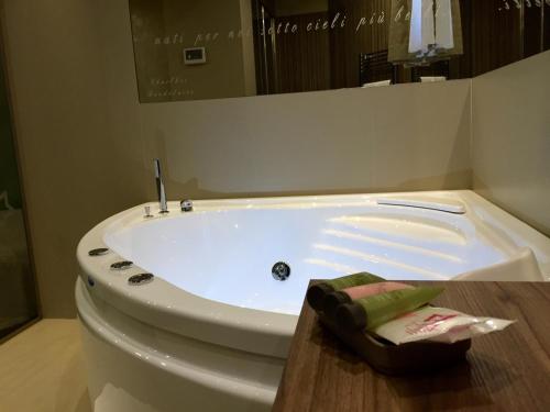 a white bath tub in a bathroom with a sink at Hotel Smeraldo in Qualiano