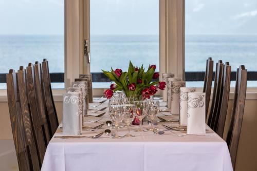 a table with a white table cloth and flowers on it at Havila Hotel Raftevold in Hornindal