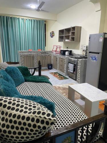 a living room with a couch and a kitchen at Diani Serena House in Ukunda