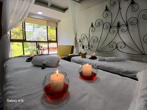 a room with two beds with candles on them at Hotel Bahia Del Faro in Guatapé