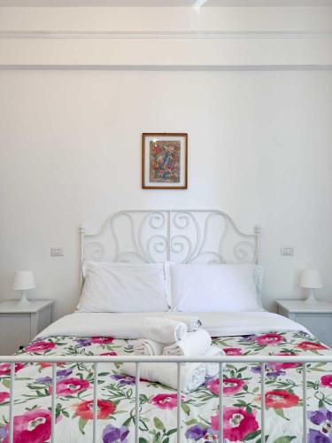 a bedroom with a white bed with a floral bedspread at Piramide Suites 2 Bedrooms & 2 Bathrooms in Rome