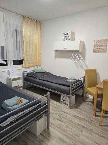 a room with two beds and a table and chairs at Ferienwohnung in Krefeld Monteurzimmer Gästezimmer Messezimmer Apartment in Krefeld in Krefeld