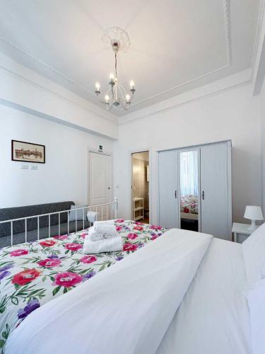 a white bedroom with a large bed with a floral bedspread at Piramide Suites 2 Bedrooms & 2 Bathrooms in Rome