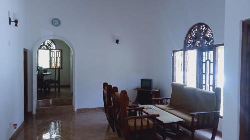 a living room with a couch and a table and chairs at The Nightingales in Dickwella