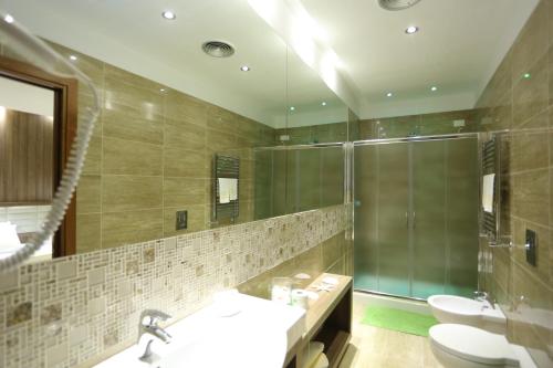 a bathroom with two sinks and a shower and a mirror at Hotel Smeraldo in Qualiano