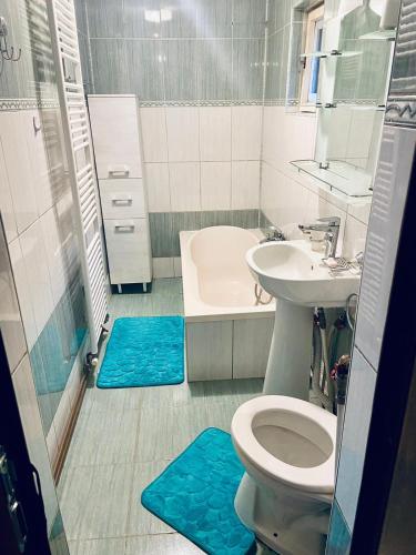 a bathroom with a toilet and a sink and a tub at Apartament 3 Closca in Floreşti
