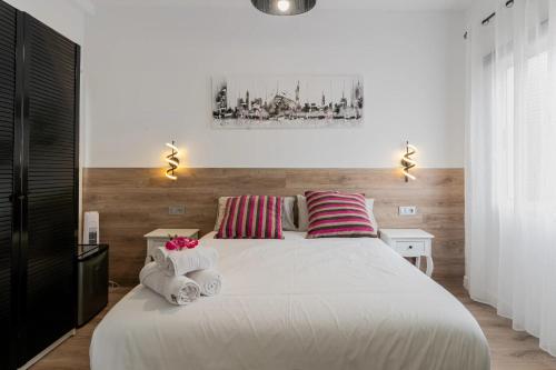 a bedroom with a large white bed with towels on it at Casa Mario Suites in Santa Cruz de Tenerife